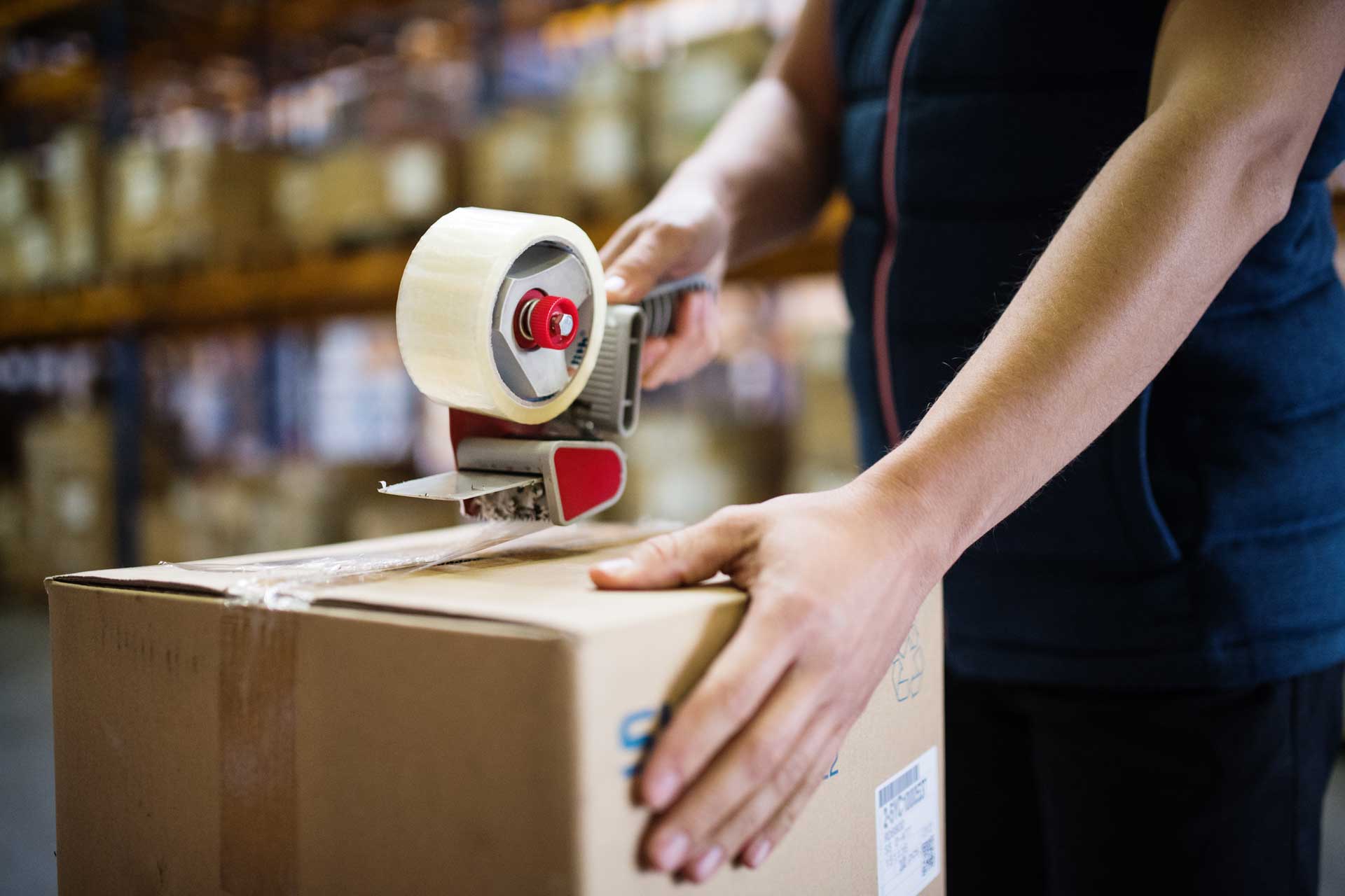 male-warehouse-worker-sealing-cardboard-boxes-PSKUTTE.jpg